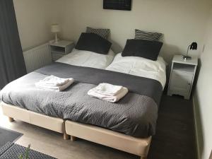 two beds in a bedroom with towels on them at Bed & Breakfast Klokgaaf in De Koog