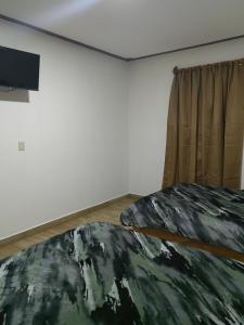 貝納爾的住宿－Posada villa aurora，一间卧室配有一张床,墙上配有电视