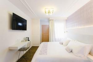 una camera bianca con letto e TV di Casa Oxa Hotel a Querétaro