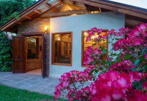 a house with pink flowers in front of it at Lujan De Cuyo B&B in Ciudad Lujan de Cuyo