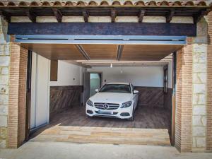 une voiture blanche garée à l'intérieur d'un garage dans l'établissement EL Rincón de Lola, à Carboneras de Guadazaón