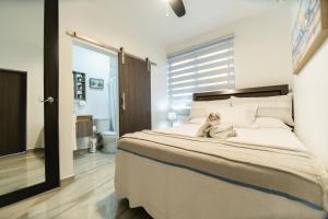 a dog sitting on a bed in a bedroom at Casa Sofía, Aventura Romántica en Rincón in Rincon