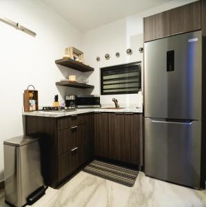 a kitchen with a refrigerator and a sink at Casa Sofía, Aventura Romántica en Rincón in Rincon