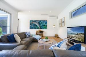 een woonkamer met een bank en een tv bij The Portsea Hideaway in Portsea