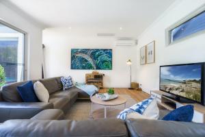 a living room with a couch and a tv at The Portsea Hideaway in Portsea