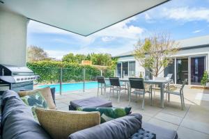 a patio with a couch and a table and chairs at The Portsea Hideaway in Portsea
