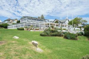 a large white building with a lawn in front of it at The Portsea Hideaway in Portsea