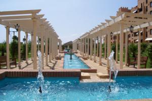 una piscina con fuentes de agua frente a un edificio en Apartment on The Beach Front with Free Fibre Internet and Air Conditioning, en Isla Canela