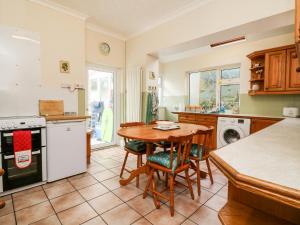 a kitchen with a table and chairs and a stove at Hele Beach in Ilfracombe