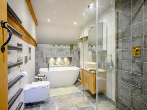 a bathroom with a tub and a toilet and a shower at Dassett View in Fenny Compton