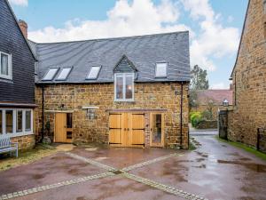 an old brick building with two garage doors and a roof at Dassett View in Fenny Compton