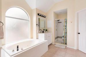 a white bathroom with a tub and a shower at Grand Gem for Families - Games, Office, Backyard in Carrollton