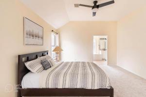 a bedroom with a large bed and a ceiling fan at Grand Gem for Families - Games, Office, Backyard in Carrollton