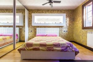 a bedroom with a bed and a ceiling fan at Andy's cozy little place in Baggio