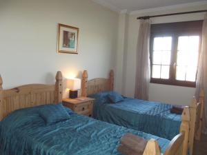 1 dormitorio con 2 camas y ventana en Apartment on The Beach Front with Free Fibre Internet and Air Conditioning, en Isla Canela
