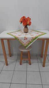 a table with a vase of flowers on top of it at Apart hotel em Caldas Novas in Caldas Novas