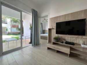 a living room with a flat screen tv on a wall at Casa Mulata Coral Village Pool & Playa in Punta Cana