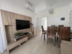 ein Wohnzimmer mit einem TV und einem Esstisch in der Unterkunft Casa Mulata Coral Village Pool & Playa in Punta Cana