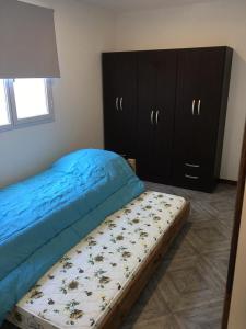 1 dormitorio con 1 cama con sábanas azules y vestidor en Departamento nuevo a estrenar en Necochea