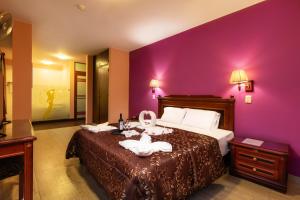 a hotel room with a bed with purple walls at La Primacía in Lima