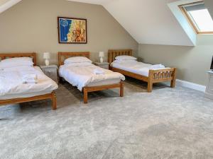 a room with three beds in a attic at Bod Eithin in Harlech