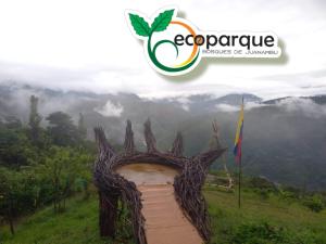 a sign on a hill with a mountain in the background at Ecoparque in Buesaco