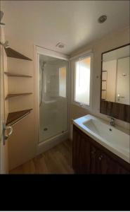 a bathroom with a shower and a sink and a tub at Camping les Cigales - Mobil-home 4/6 personnes in Le Muy