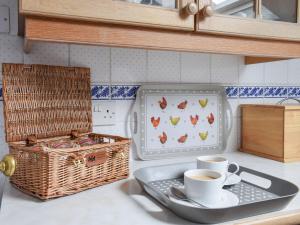 two cups of coffee on a tray on a kitchen counter at Meadow View in Tregoney