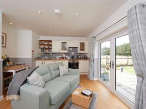 a living room with a couch and a kitchen at Barn Owl Cottage in Inver