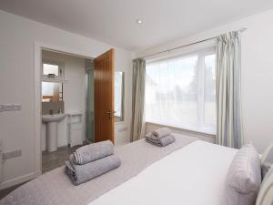 a white bedroom with a large window and a bed at Barn Owl Cottage in Inver