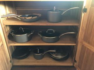 a shelf with pots and pans in a cabinet at Pretty house Bastimentos Bocas del toro in Bastimentos