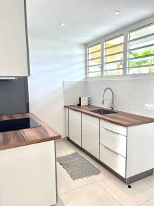 a kitchen with white cabinets and a sink at Reves Bleus in Le Gosier