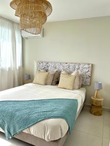 a bedroom with a large bed with pillows at Reves Bleus in Le Gosier