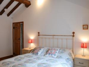 a bedroom with a bed with two lamps on tables at The Annex in Chelford