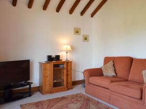 a living room with a couch and a television at The Annex in Chelford