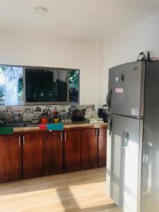 a kitchen with a stainless steel refrigerator and wooden cabinets at Cabaña la isla in Coveñas