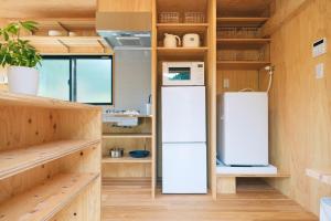 einen Kühlschrank in einer Küche mit Holzwänden in der Unterkunft 安全第一 客室　コンテナハウス in Nishiawakura