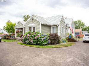 a white house with flowers in a driveway at Cozy Home for Family & Friends Gathering in Beaverton
