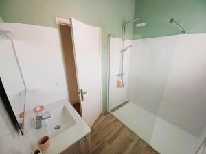 een badkamer met een wastafel en een douche bij DOLUS, Maison à 10 min. de la plage! in Dolus d'Oléron