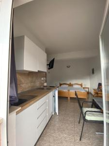 a kitchen with white cabinets and a bed in a room at Studio Zuljana 4576a in Žuljana