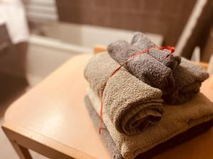 sterta ręczników na stole w obiekcie Résidence CAENEE, le dépaysement Naturiste en été avec l'atypique studio climatisé "vintage" en sous pente, sa "paillote" avec jacuzzi, entouré de verdure, planchagrill, transats, vélos gratuits, wifi 5G, Travel Proud LGBTQI, chiens admis w mieście Marseillan