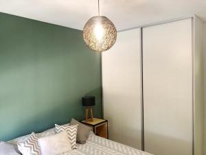 1 dormitorio con cama y lámpara de araña en Luminoso departamento en Godoy cruz en Godoy Cruz