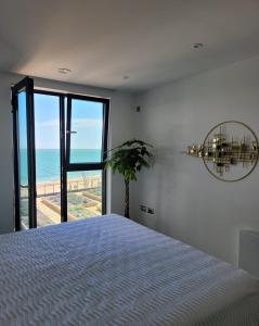 a bedroom with a bed and a view of the ocean at Royal View in Ramsgate