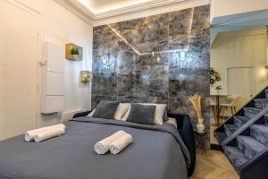 a bedroom with a bed and a stone wall at Le studio de l'île in Paris