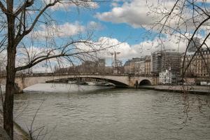 a bridge over a river in a city at Le studio de l'île in Paris