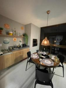 uma cozinha com uma mesa com cadeiras e um lavatório em Apartamento na Praia do Francês em Praia do Francês
