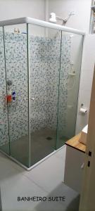 um chuveiro com uma porta de vidro na casa de banho em Ponta da Praia amplo 3dorm 3ban frente ao mar em Santos