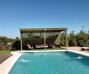 a swimming pool in a backyard with a gazebo at Cabañas Segundo Piso in Algarrobo