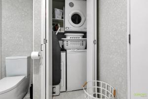 y baño con lavadora, lavadora y secadora. en QV Modern Waterfront 2-bedroom apartment - 079 en Auckland