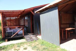 een klein huis met een veranda en een patio bij Cabañas Alfa Colbun Machicura in Linares